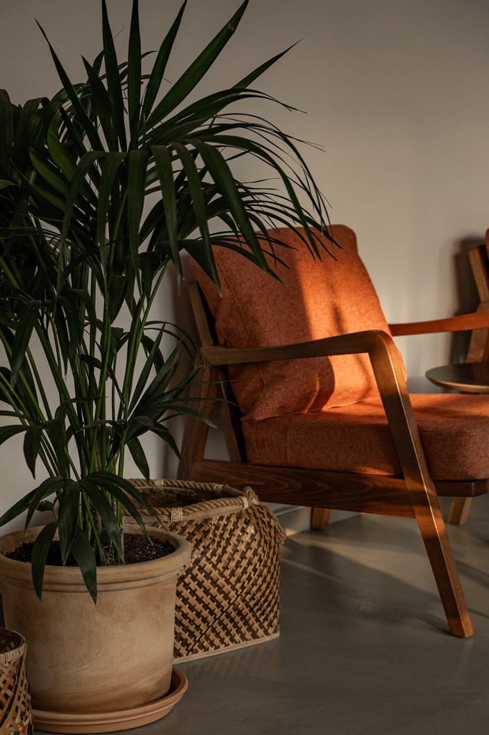 Corner seating in lobby with orange armchair and plants Hersonissos