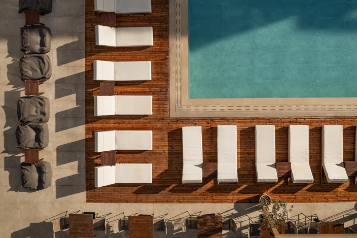Top down angle of the corner of the pool with white lounge chairs Hersonissos 